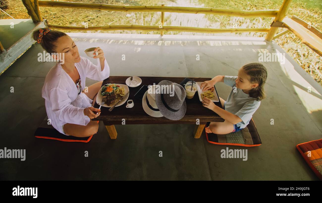 The happy family eat and drink tasty beverages spending time in local