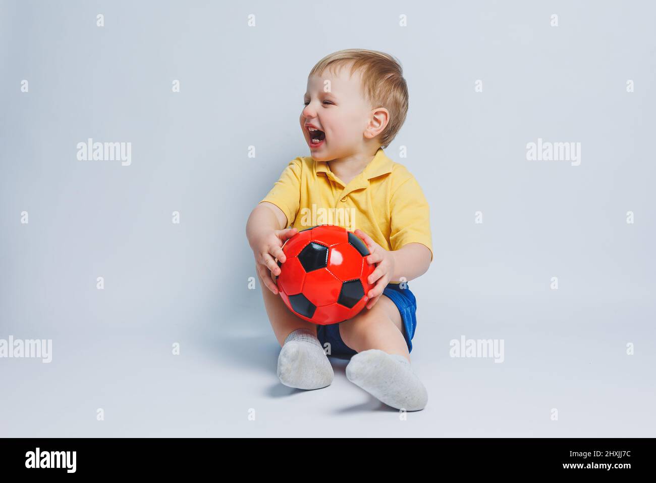 Boy 34 years old football fan in a yellow Tshirt with a ball in his