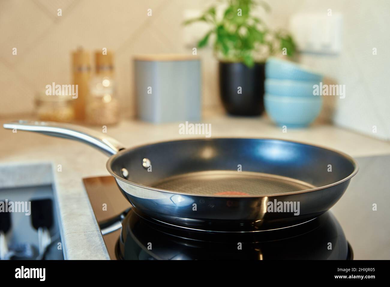 Steel frying pan in the kitchen on electric induction hob, Modern