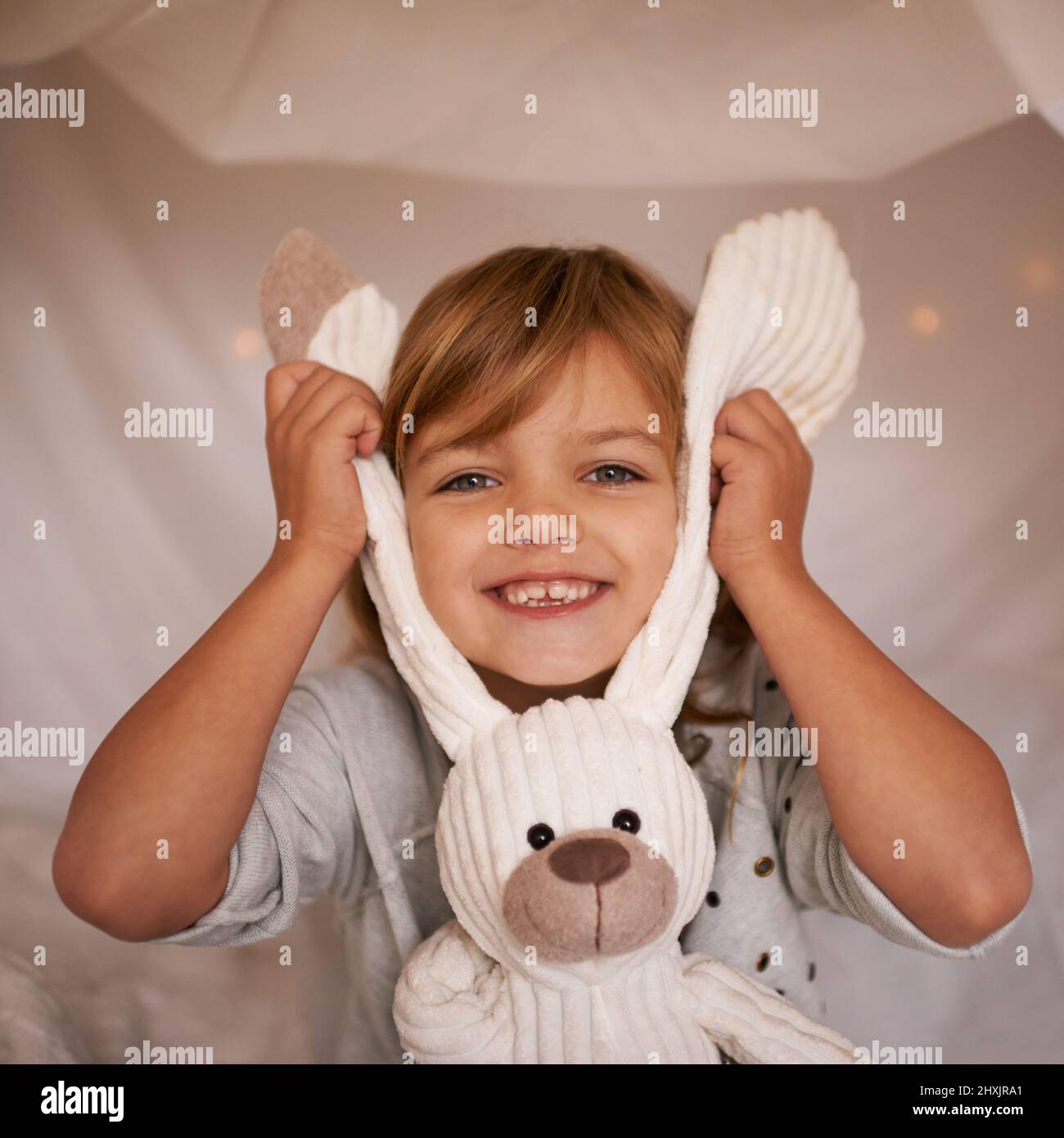 My funny bunny. Portrait of an adorable little girl playfully holding her toy rabbit. Stock Photo
