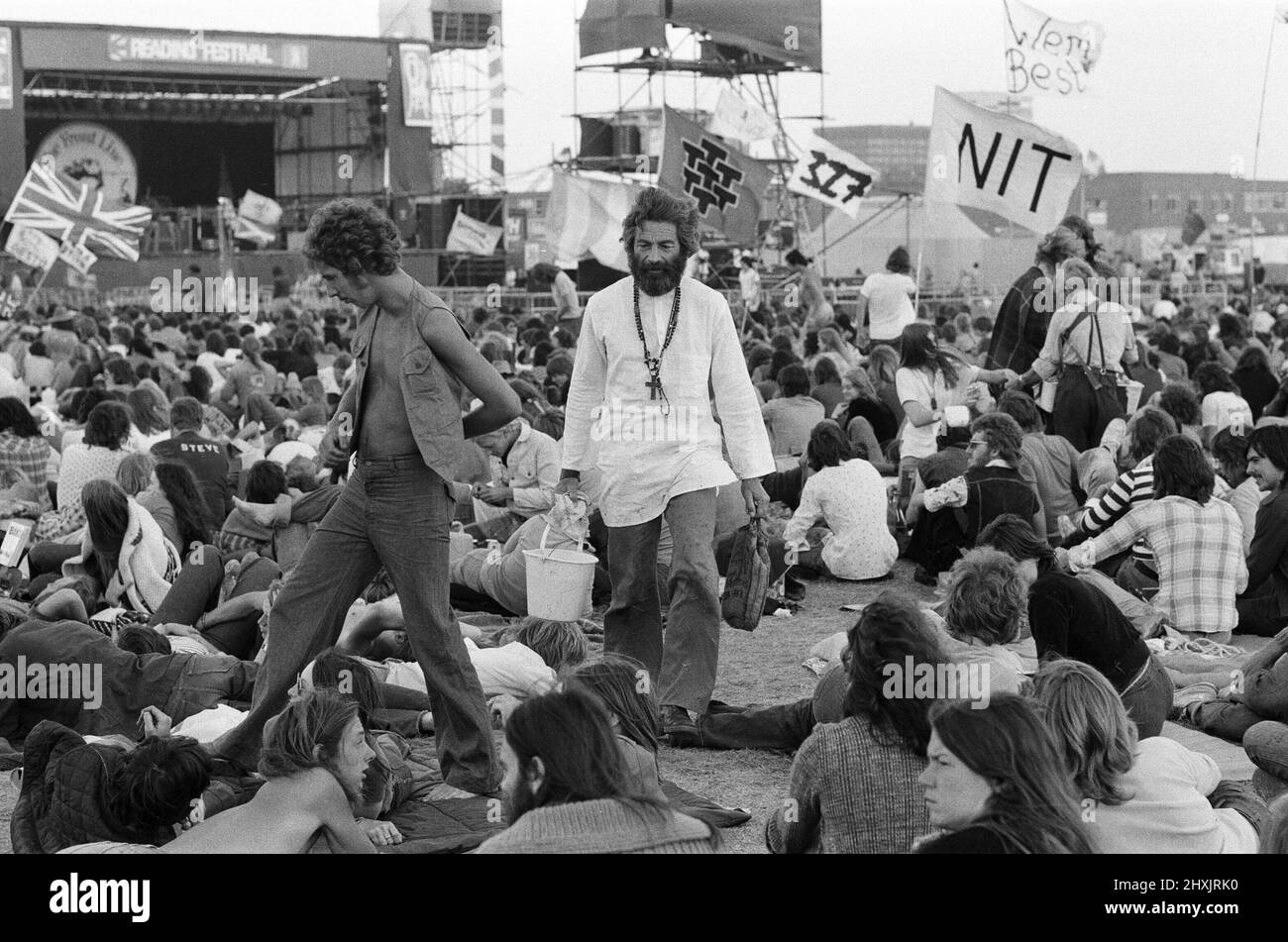 'Mick the Vic', who is the Rev Michael Scott, Vicar at St Mark's Church, Reading, tours the festival site at reading, washing the feet of pop fans. 27th August 1976. Stock Photo