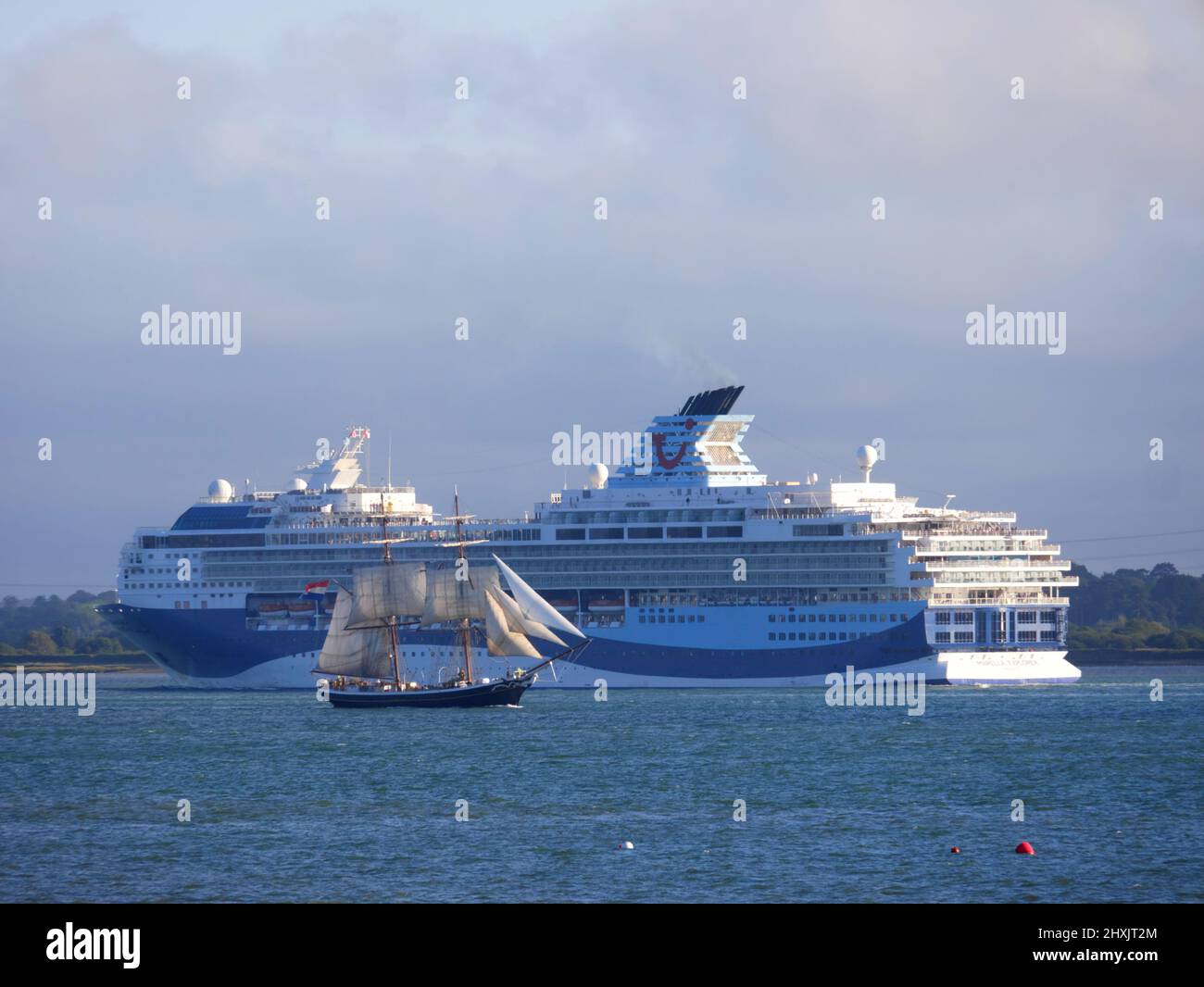 TUI cruise ship Marella Explorer passes SV Tenacious as she leaves Southampton, Hampshire. Stock Photo