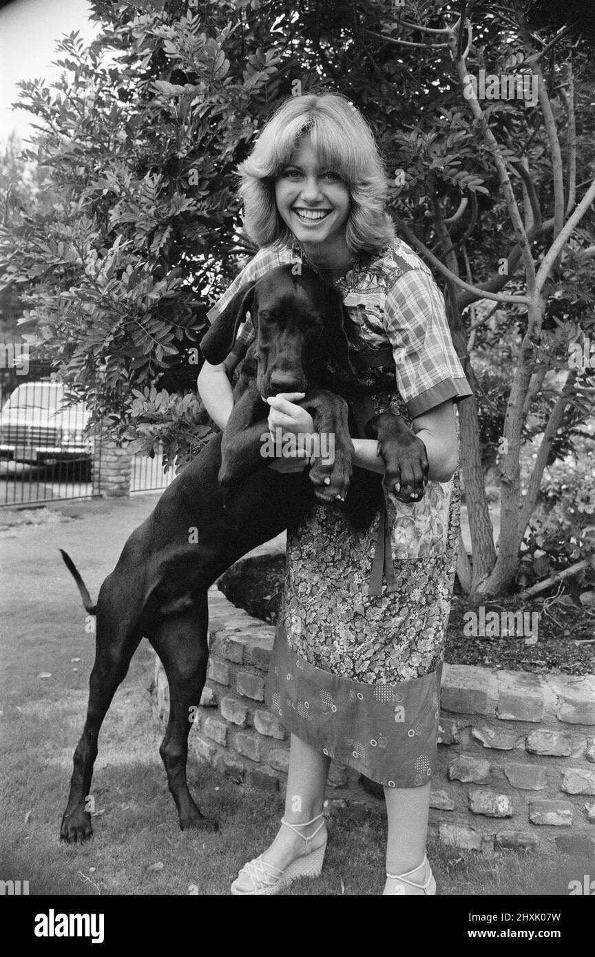 Olivia Newton John, singer and actor, pictured at home in Malibu, California, America.Pictured here with one of her dogs.   Picture taken 25th July 1976 Stock Photo