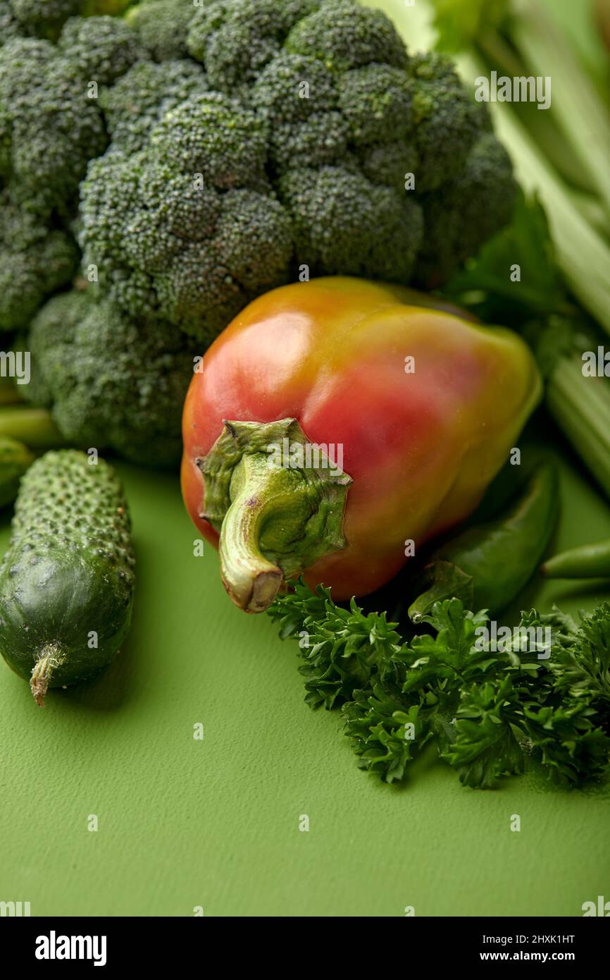 cucumber, broccoli and other green fresh vegetables just from garden, healthy food nutrition concept. flat lay, on green wall. close-up photo Stock Photo