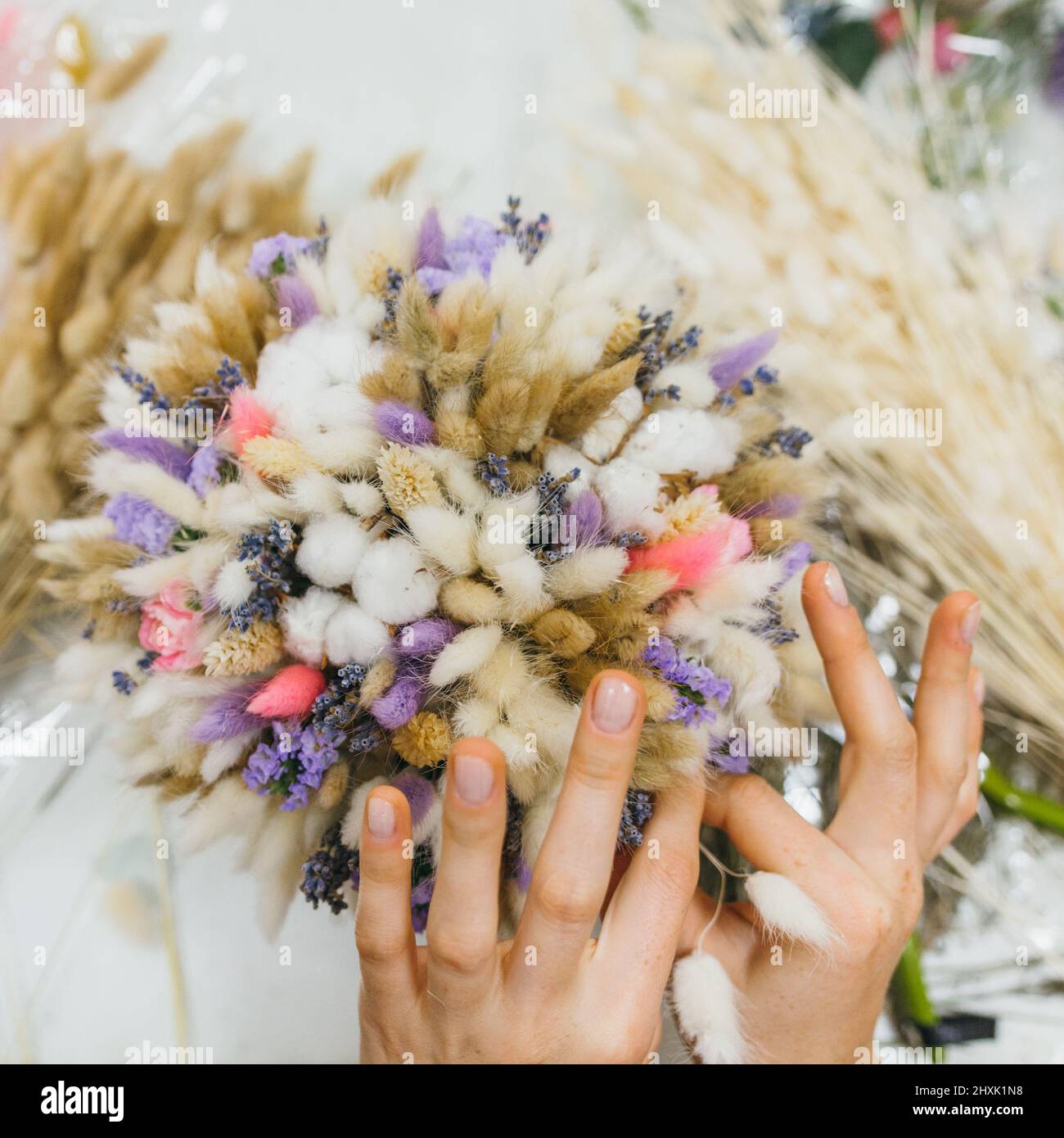 Colorful bouquet of different dried flowers deadwood flowers in the hands of a florist woman. Rustic flower background. Craft bouquet of flowers. The Stock Photo