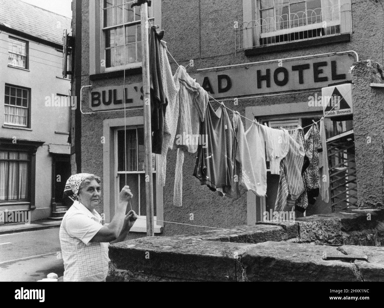 Hotel Landlady Mrs Maureen Roach puts up another line of washing outside the Bull's Head Hotel, Brecon, a market town and community in Powys, Mid Wales, 25th July 1977. Stock Photo