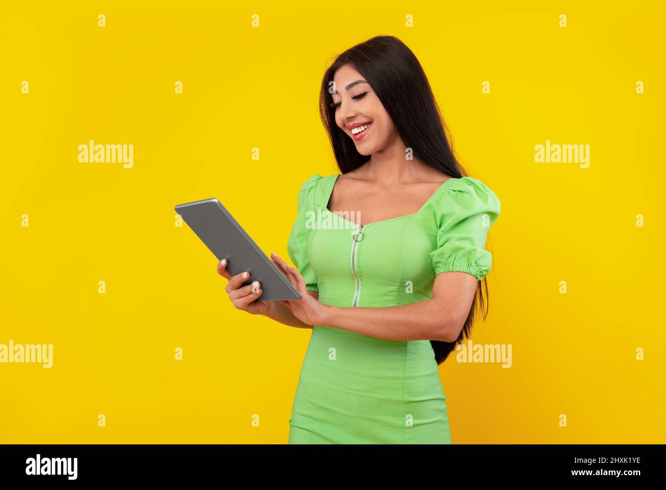 Cheerful young woman using tablet at studio Stock Photo