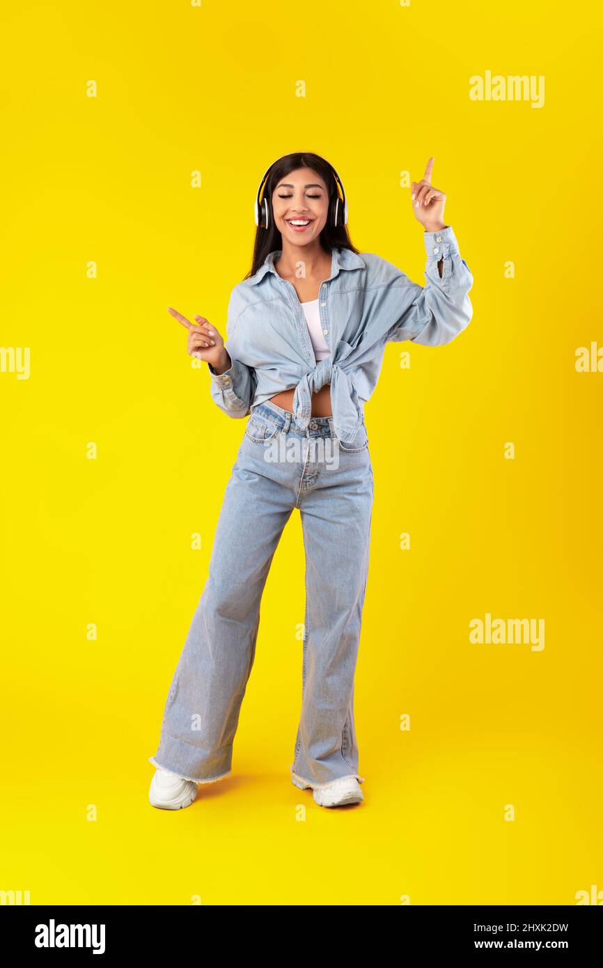 Excited Young Woman Dancing Wearing Wireless Headphones Stock Photo