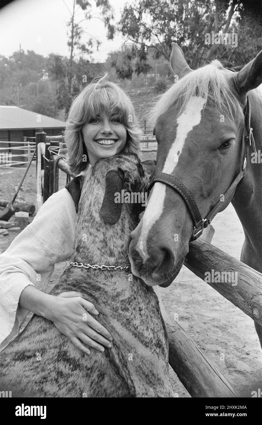 Olivia Newton John, singer and actor, pictured at home in Malibu, California, America.Pictured her with her horse and one of her dogs.   Picture taken 25th July 1976 Stock Photo