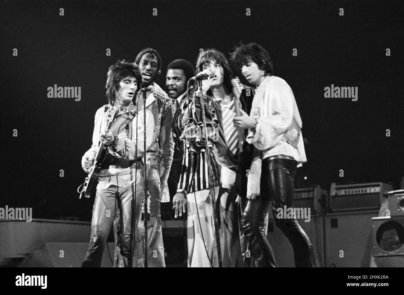 The Rolling Stones - live at Earl's Court, West London. Picture shows far left : Ronnie Wood, 2nd from the right Mick Jagger and far right Keith Richards  together onstage, with 2 of their backing singers behind them.  This concert was part of the 1976 European Tour. It started in Frankfurt Germany on 28th April and ended at Knebworth in England on 21st August 1976.  Whilst we cannot confirm the actual set list for this show, a typical set list for this tour was...  'Honky Tonk Women' 'If You Can't Rock Me'/'Get off of My Cloud' 'Hand of Fate' 'Hey Negrita' 'Ain't Too Proud to Beg' 'Fool to Cr Stock Photo