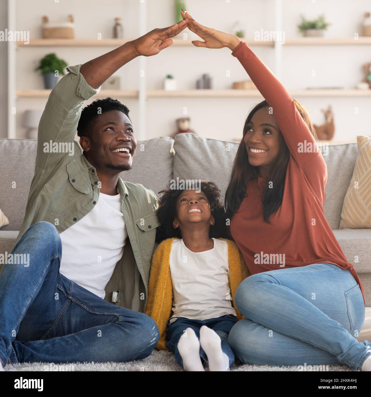 Family Care. Black Mom And Dad Making Roof Of Hands Above Daughter