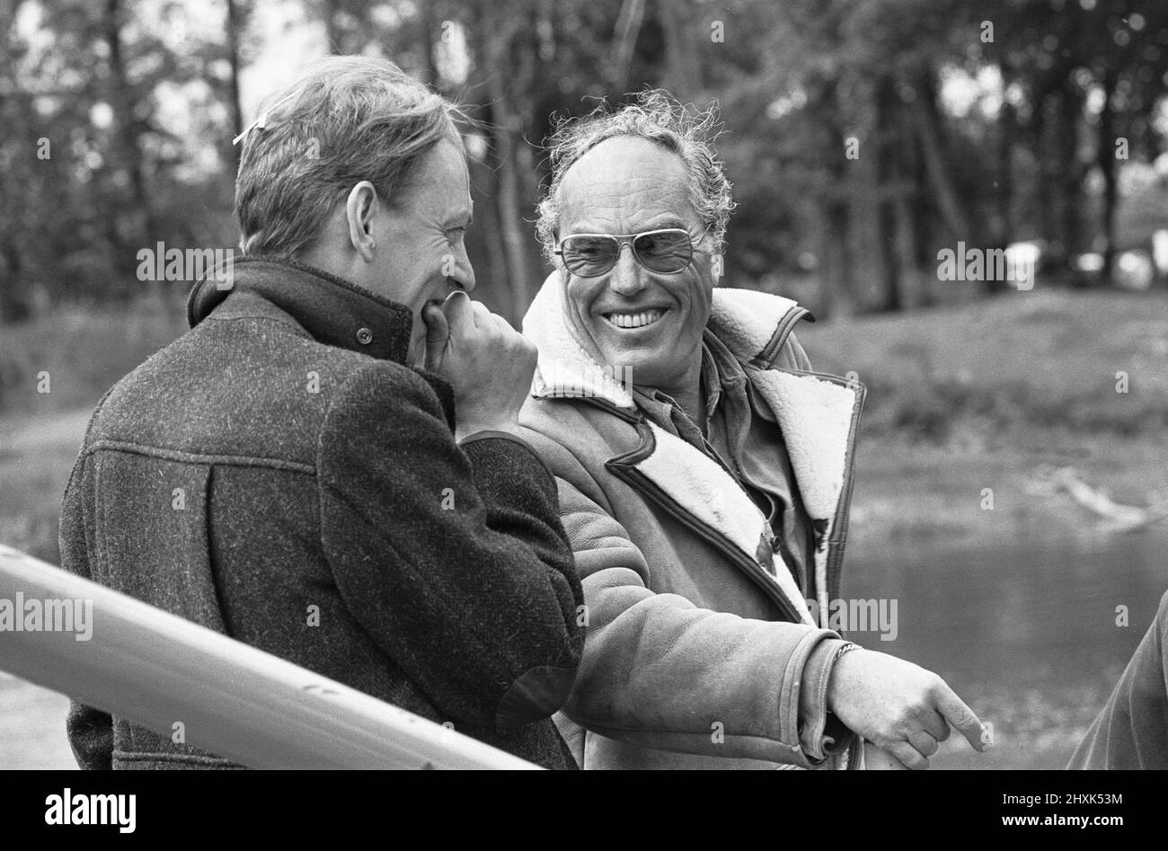 Director John Sturges (right) seen here with actor Donald Sutherland during location filming for The Eagle Has Landed at Mapledurham 14th June 1976 Stock Photo