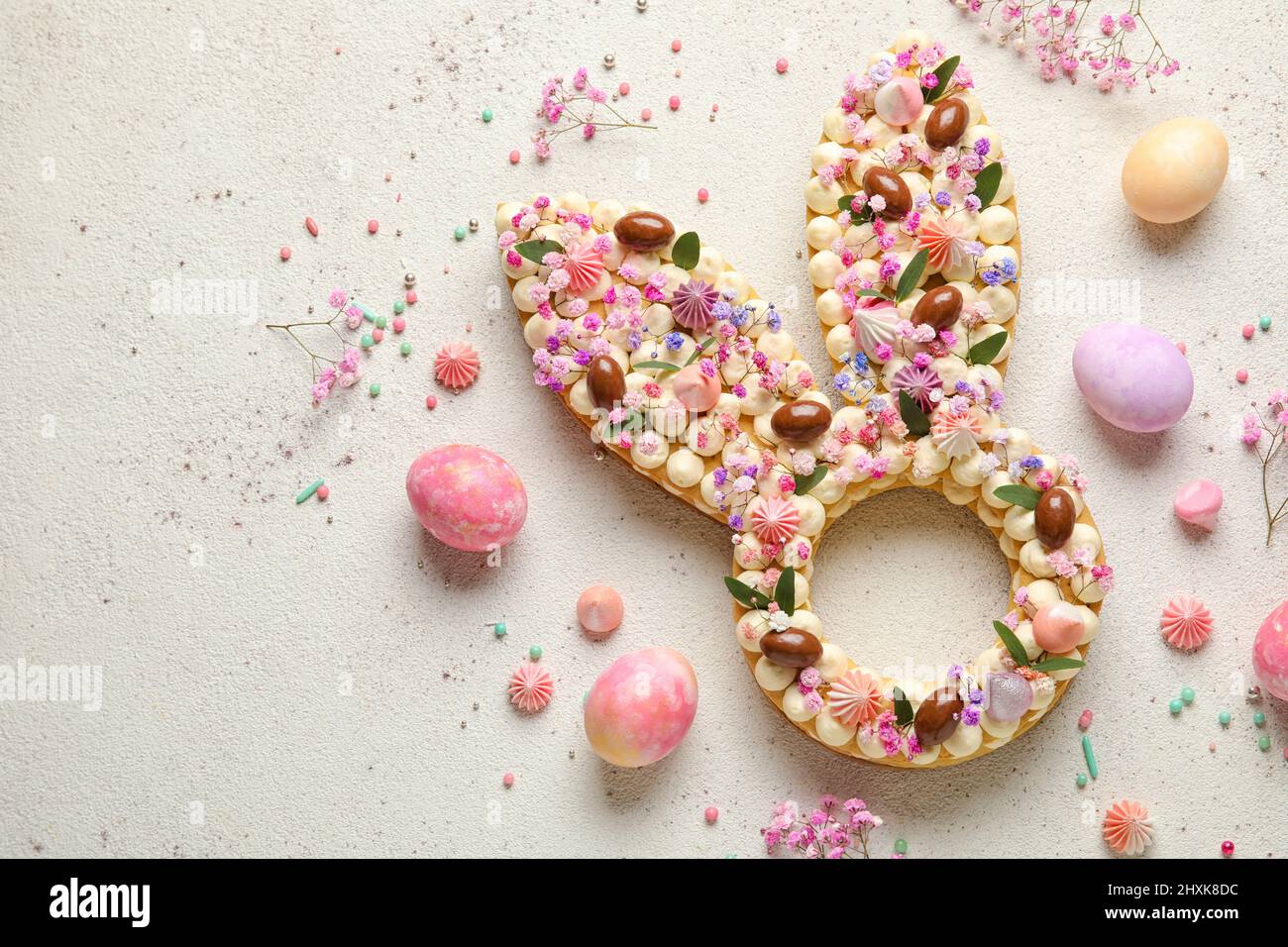 Composition with beautiful cake and painted eggs for Easter celebration on light background Stock Photo