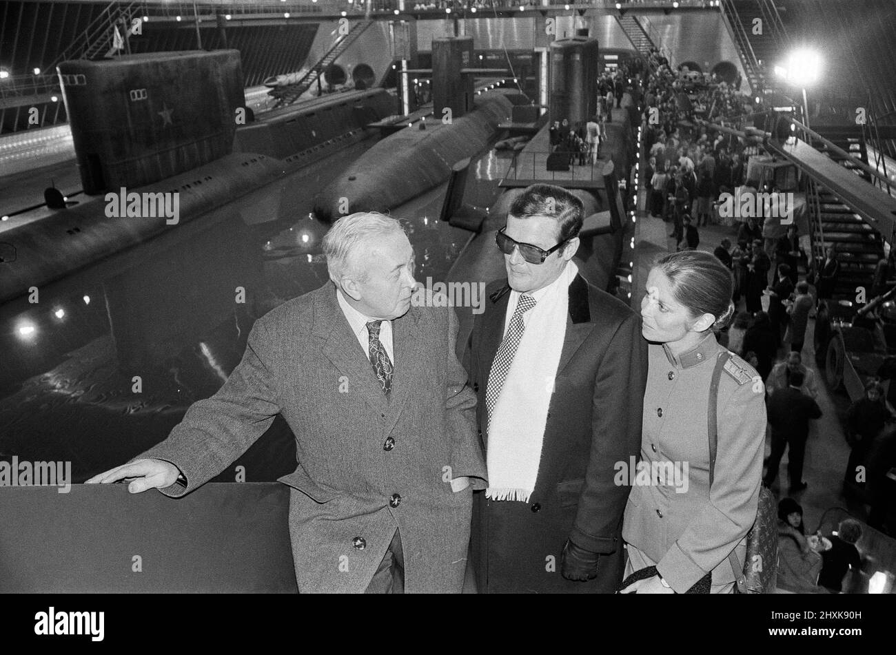 Sir Harold Wilson visited Pinewood Studios to officially open the largest film stage in the world which was created for scenes featuring a super tanker and three submarines in the latest James Bond epic ' The Spy Who Loved Me'. Sir Harold Wilson is pictured with Roger Moore and Barbara Bach. 5th December 1976. Stock Photo