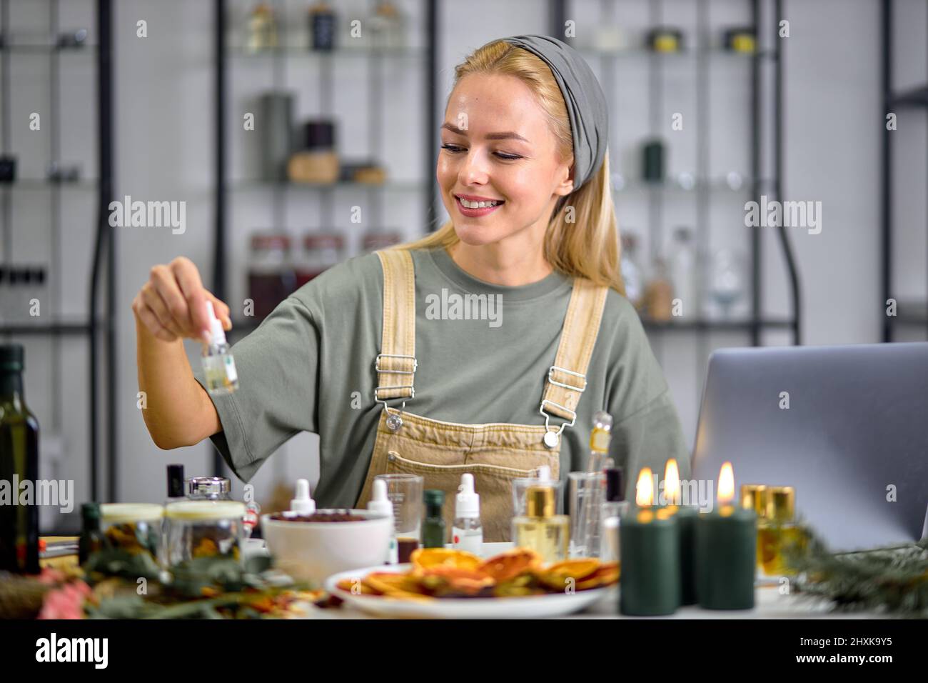 fragrance is tested and mixed scent by a professional perfumer before making another one. smiling attractive caucasian lady in apron uniform at work p Stock Photo