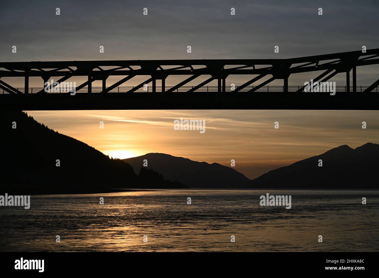 Ballachulish Bridge in Scottish Highlands at sunset with loch and mountains in view. Stock Photo