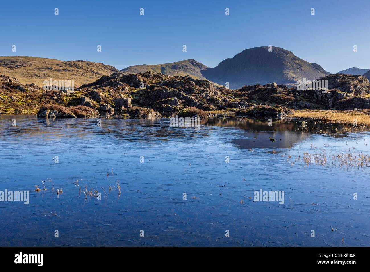 A frozen Innominate Tarn in the winter with Great Gable in the background, Lake District, England Stock Photo