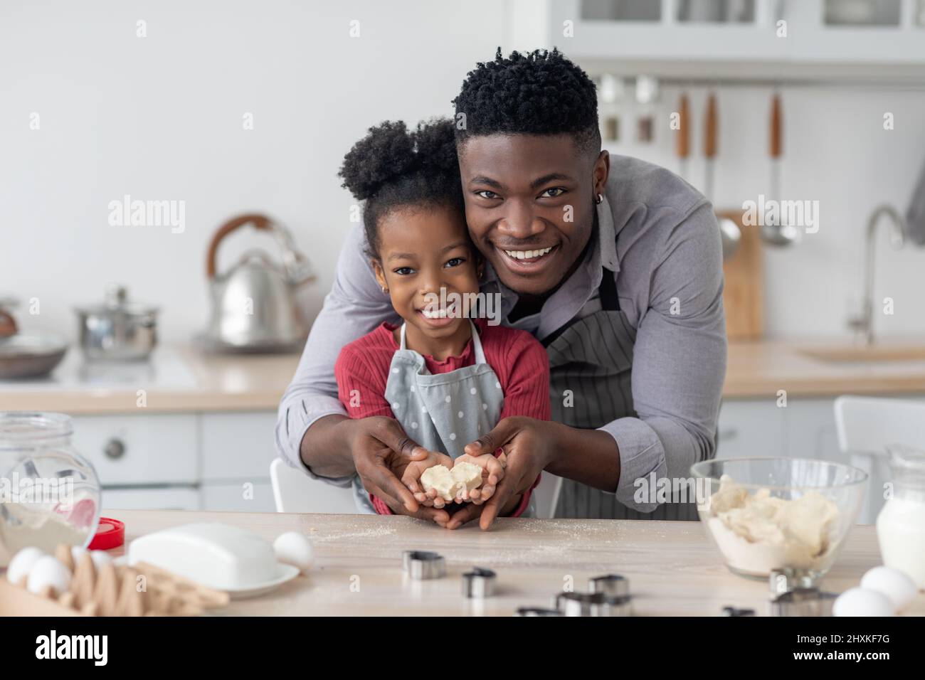 Happy black father and daughter making cookies in heart shape Stock ...
