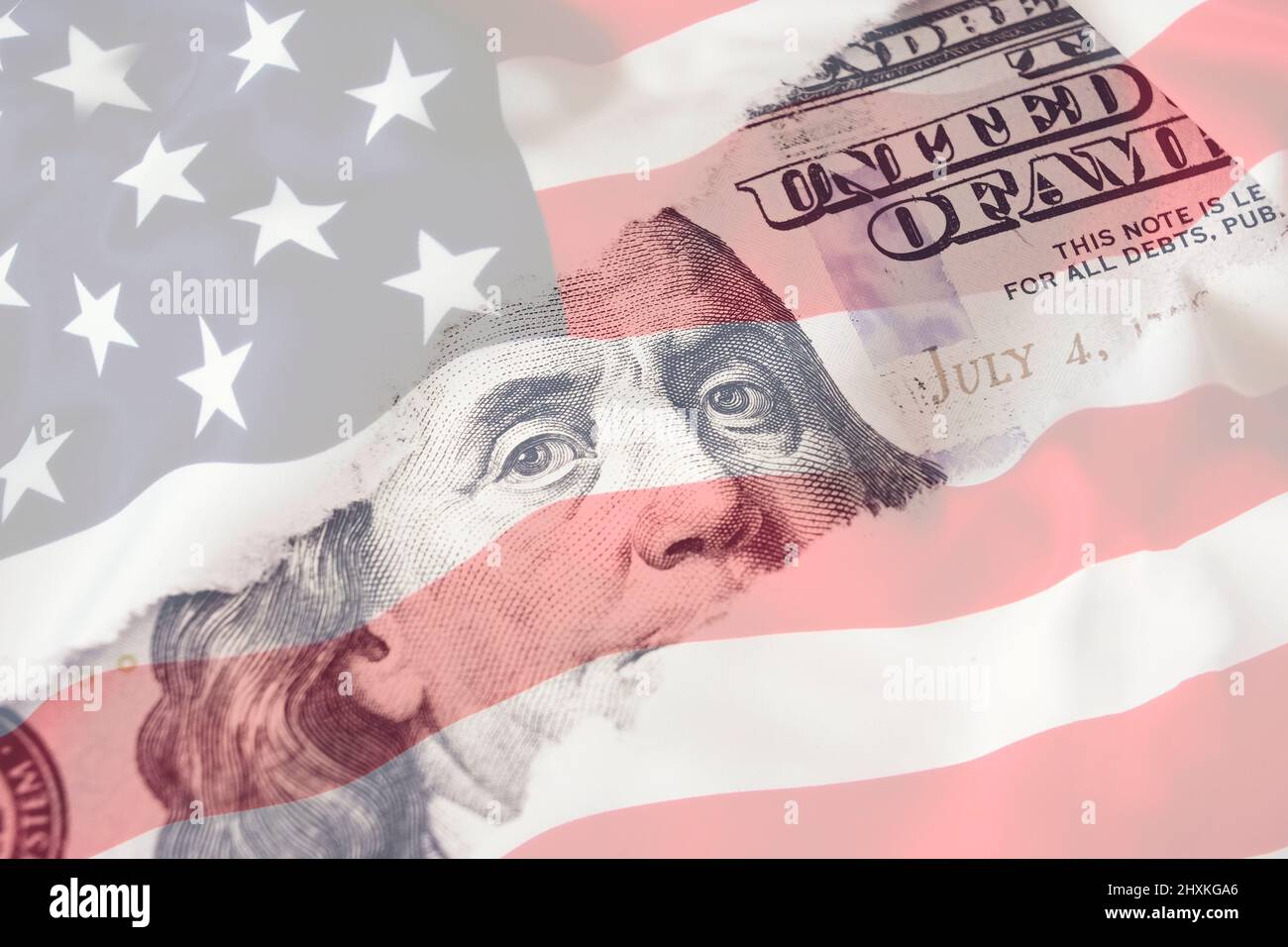 Portrait of US president Benjamin Franklin 100 dollars banknote on american flag background. Economy, savings and the US dollar Stock Photo