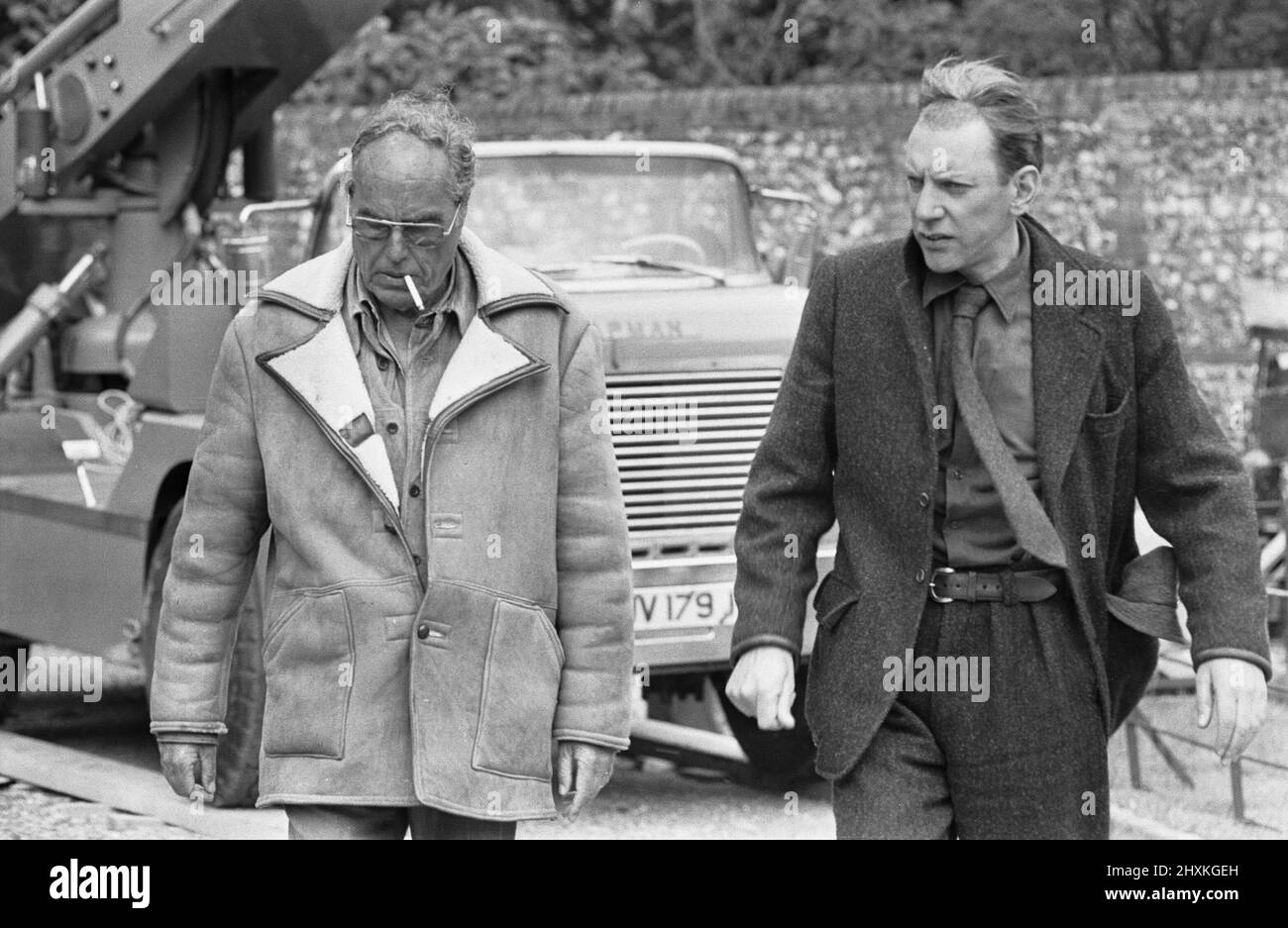Director John Sturges (left) seen here with actor Donald Sutherland during location filming for The Eagle Has Landed at Mapledurham 14th June 1976 Stock Photo