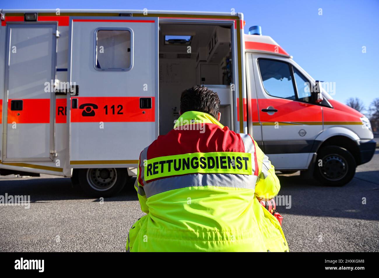 Zeuthen, Germany. 11th Mar, 2022. "Rescue service" is written on the jacket of a man squatting in front of an ambulance of the Zeuthen fire department. Filming is taking place here for the Sat.1 series "Lenßen übernimmt" on the subject of "attacks on emergency services. The episode is broadcast as part of a special week on the topic of "victim protection. Credit: Jens Kalaene/dpa-Zentralbild/dpa/Alamy Live News Stock Photo