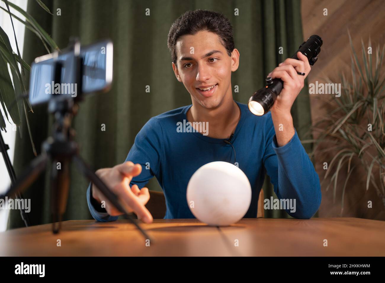 arab Guy-photographer records a video tutorial for photographers and a video of graphs talks about constant light using a flashlight. Online photograp Stock Photo