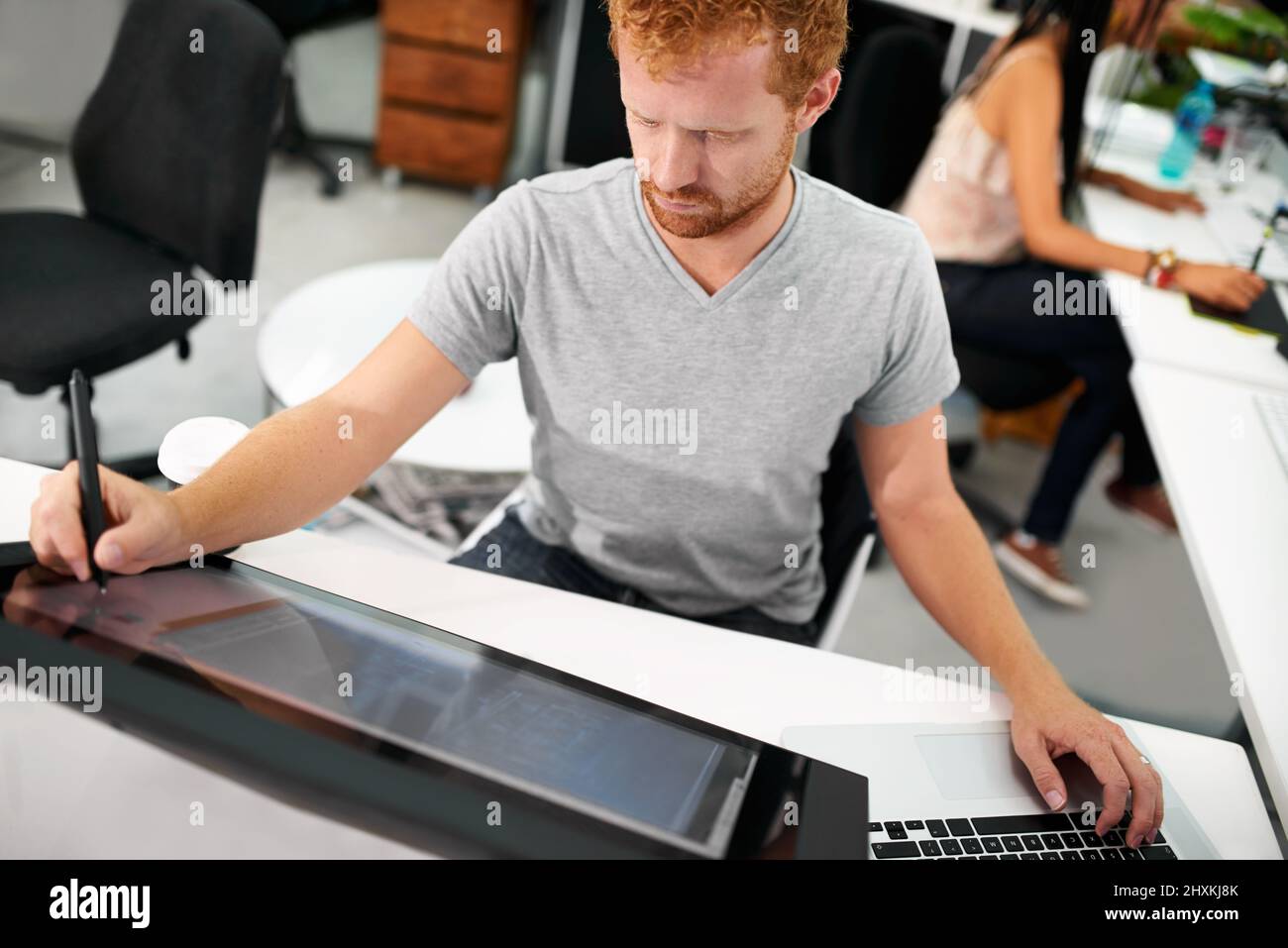 Smart technology makes everything easier. A young man working on a large touchscreen. Stock Photo