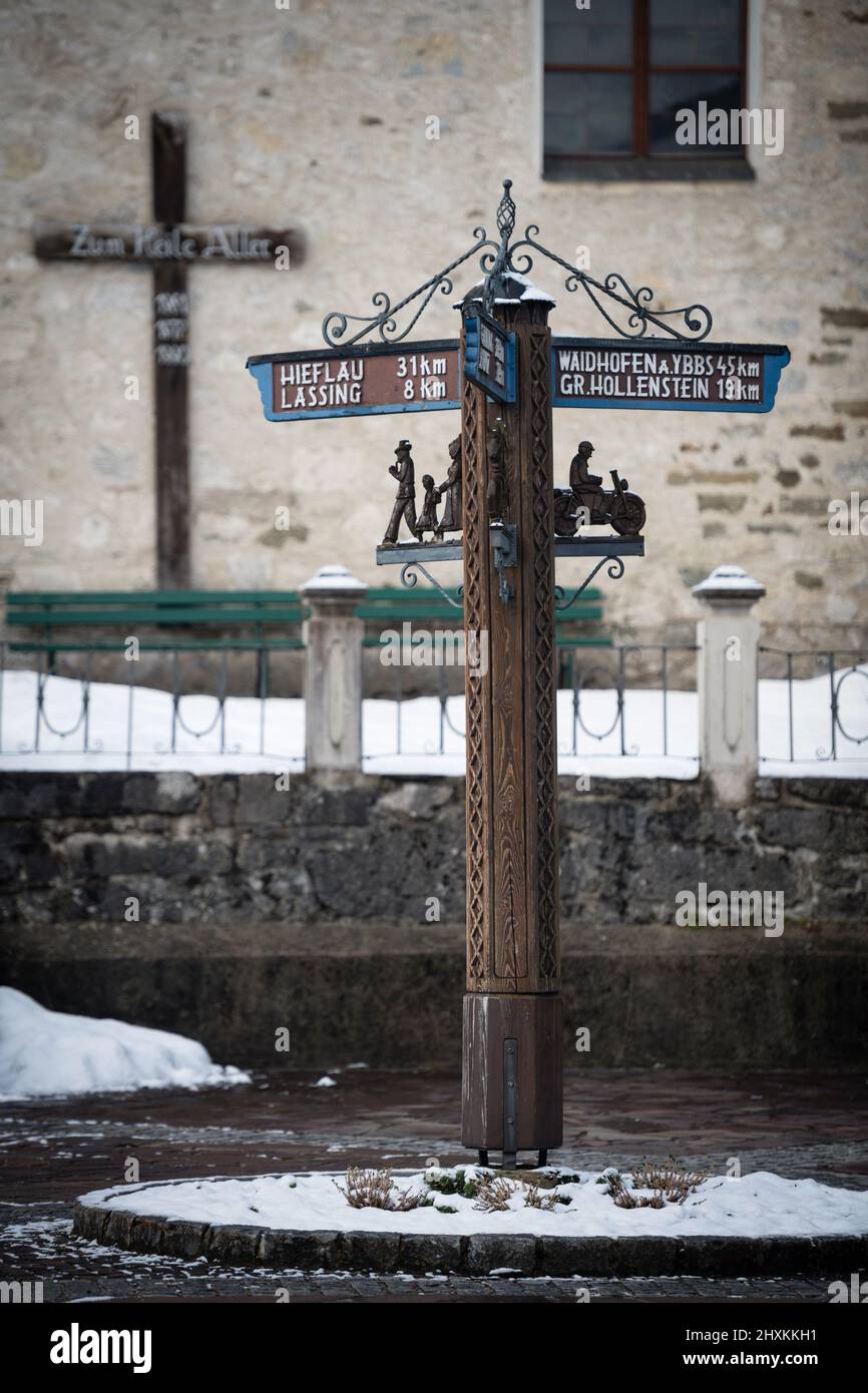 Old wooden road sign in front of church at Gostling an der Ybbs, Austria Stock Photo