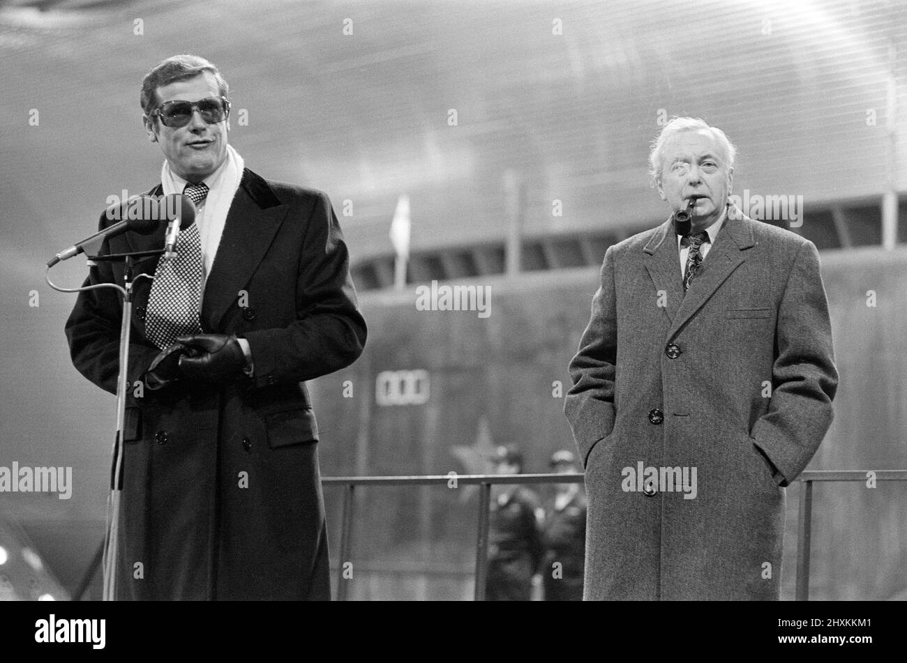 Sir Harold Wilson visited Pinewood Studios to officially open the largest film stage in the world which was created for scenes featuring a super tanker and three submarines in the latest James Bond epic ' The Spy Who Loved Me'. Sir Harold WIlson with Roger Moore. 5th December 1976. Stock Photo