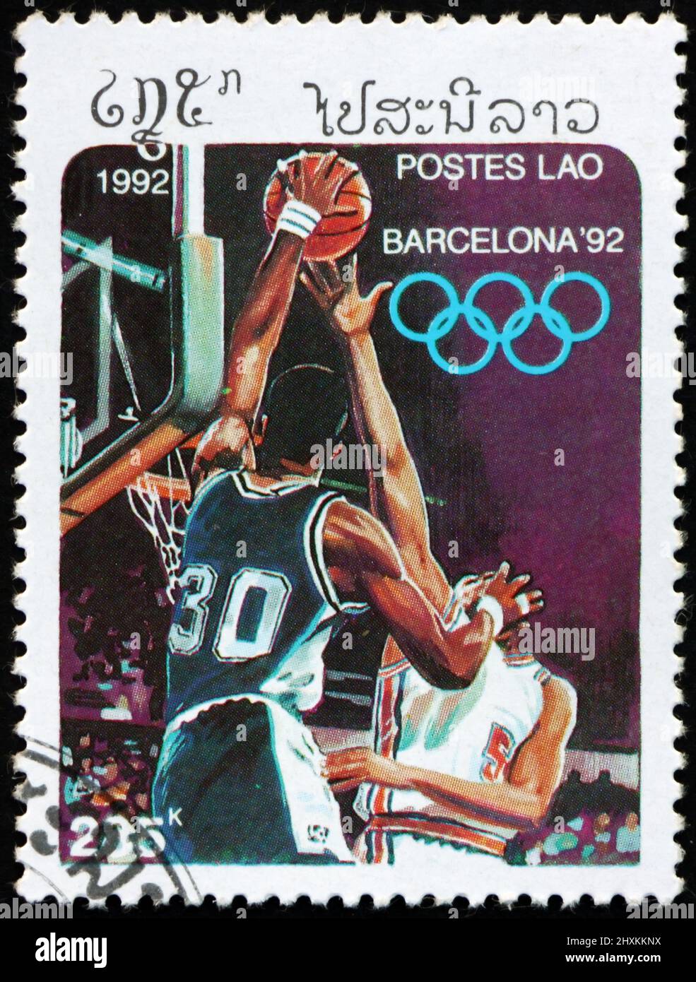 LAOS - CIRCA 1992: a stamp printed in Laos shows basketball, 1992 Summer Olympics, Barcelona, circa 1992 Stock Photo