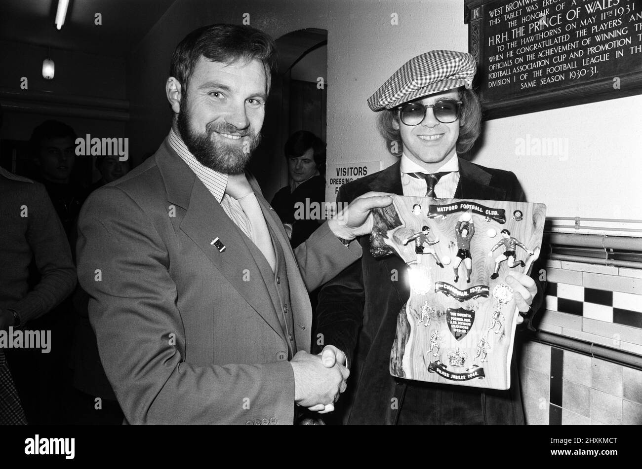 Musician and Watford FC chairman Elton John is presented with a special Jubilee plaque presented to him by West Bromwich Albion fan, Ray Egan. This was some consolation for Elton after the 1-0 defeat by Albion in the Football League Cup clash at The Hawthorns. 25th October 1977. Stock Photo