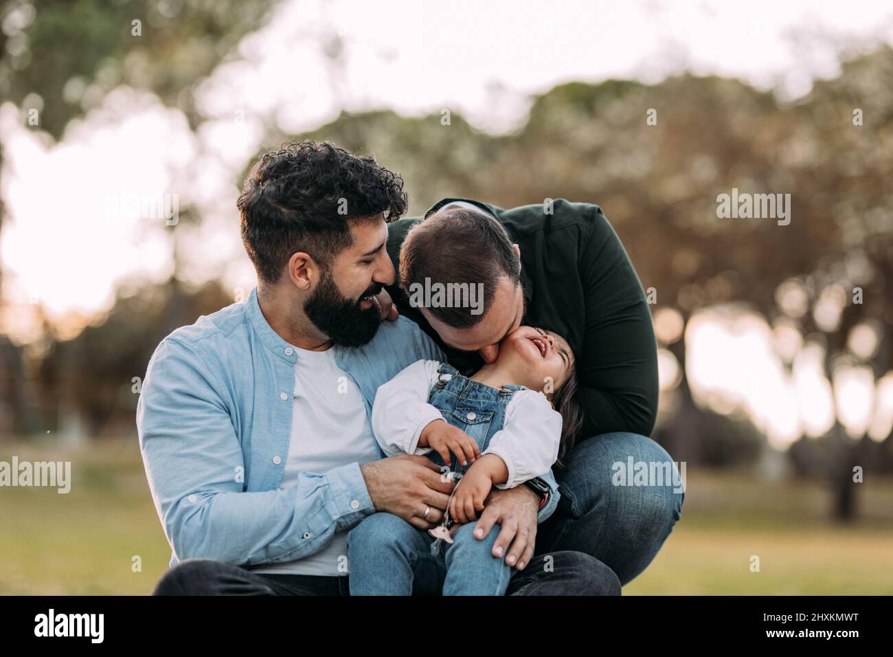 Two male gay couple with adopted child. Homosexual Couple holding hands  LGBT flag. Concept LGBT family. kids drawing pencils Stock Photo