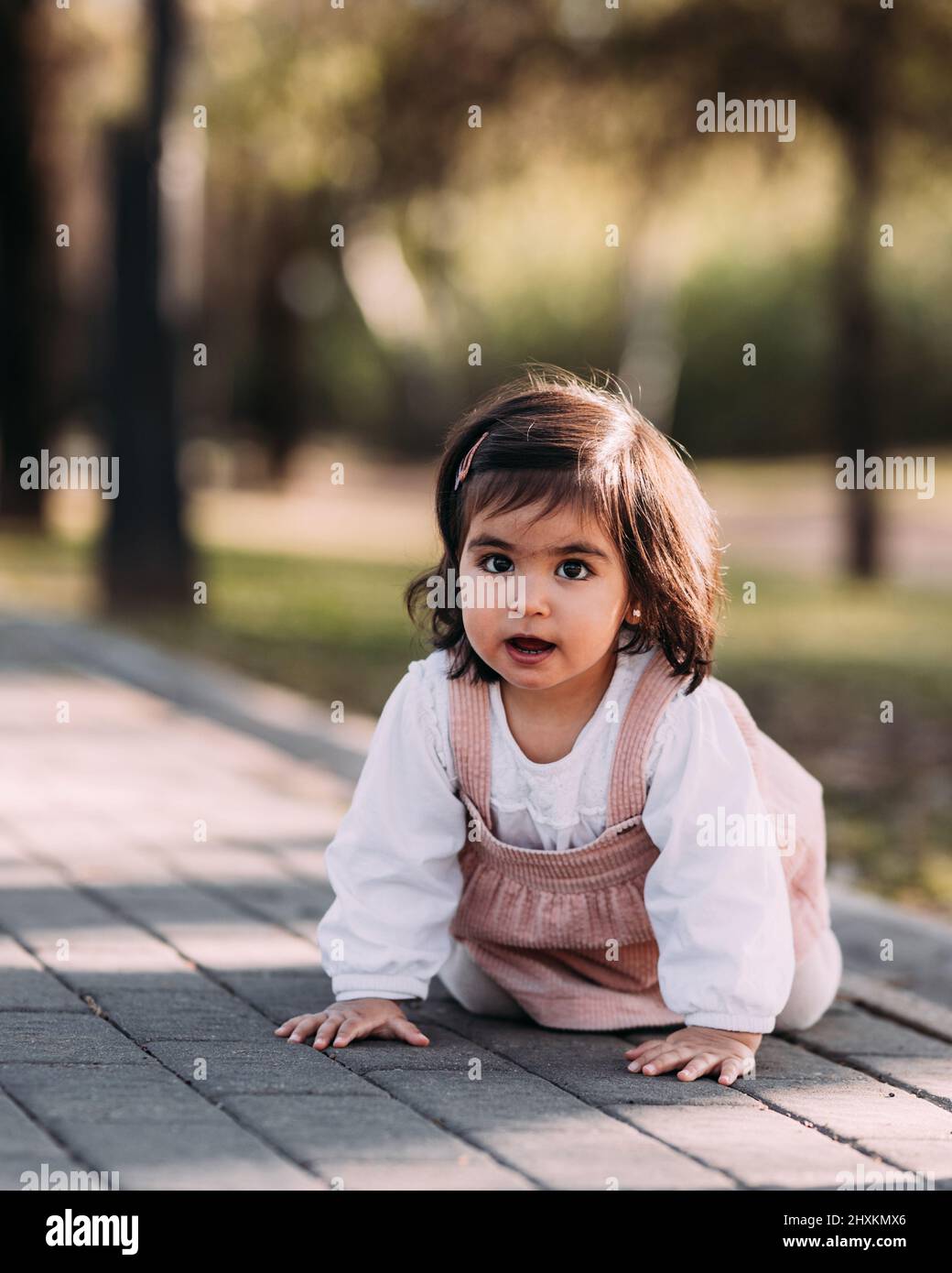 Cute little girl crawling in a park Stock Photo