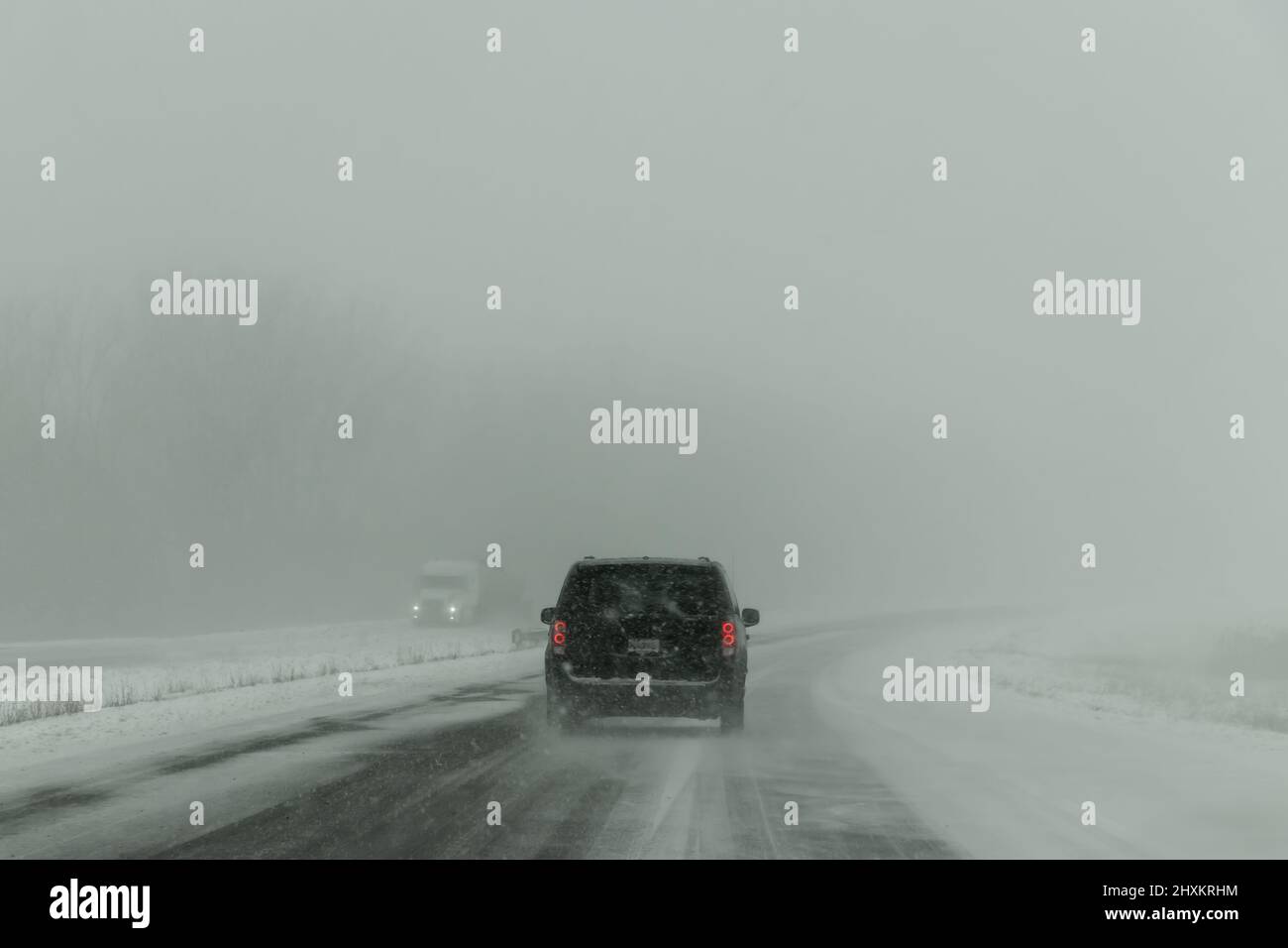 Car on highway during bad weather with snow storm in Winter - Quebec, Canada Stock Photo