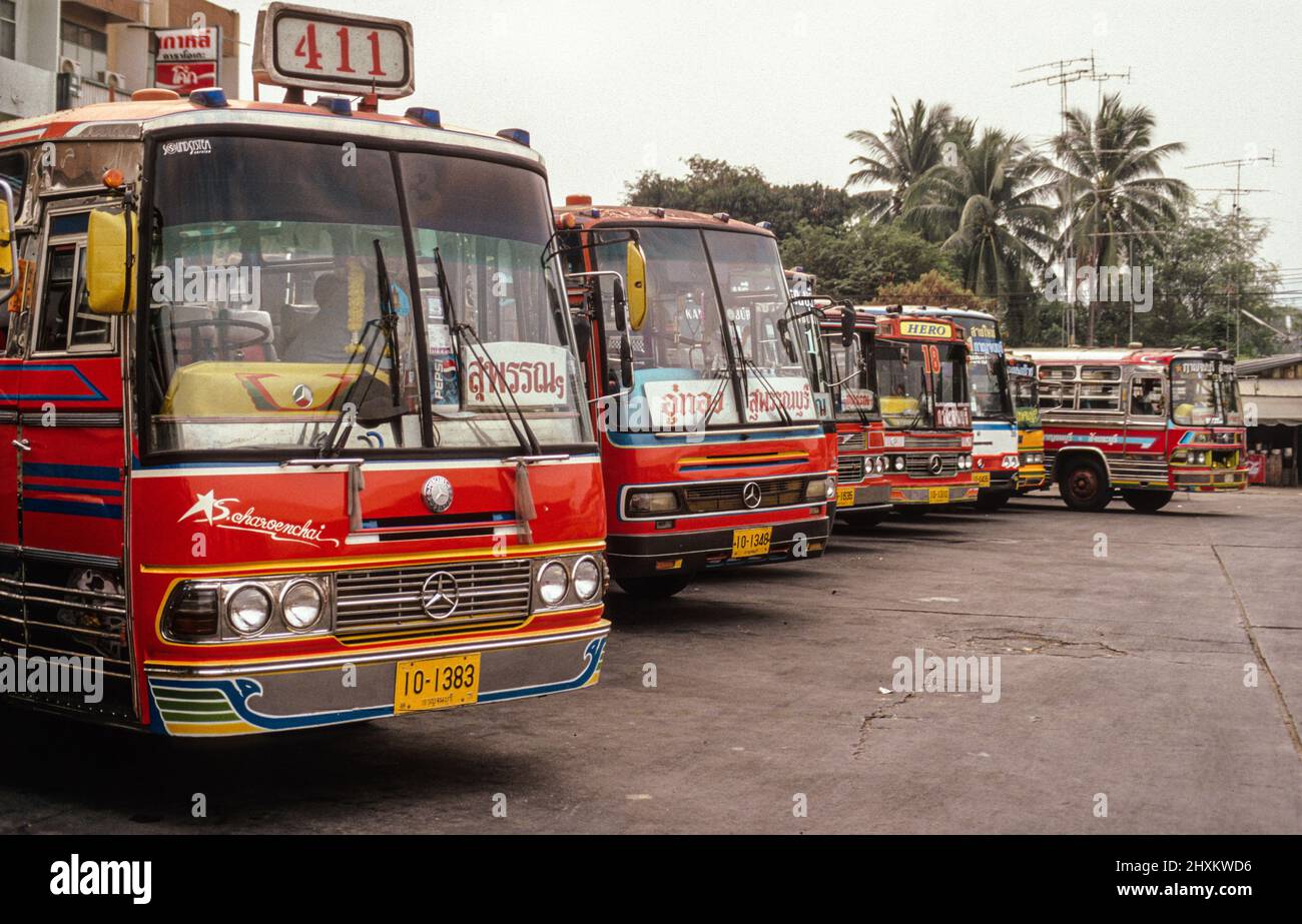 Brightly coloured buses at Kanchanaburi terminal. Stock Photo