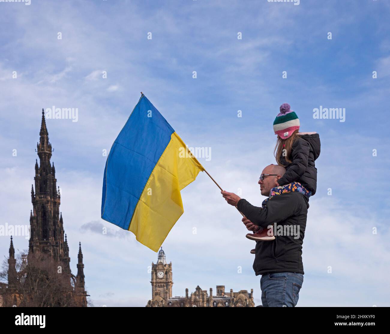 Edinburgh city centre, Scotland, UK. 13th March 2022. Poignant image of Solidarity for Ukraine, Edinburgh, Scotland, UK. Pictured: Erica on the sholders of her father flying the Ukrainian flag in support against the Russian invasion. Credit: Arch White/alamy live news. Stock Photo