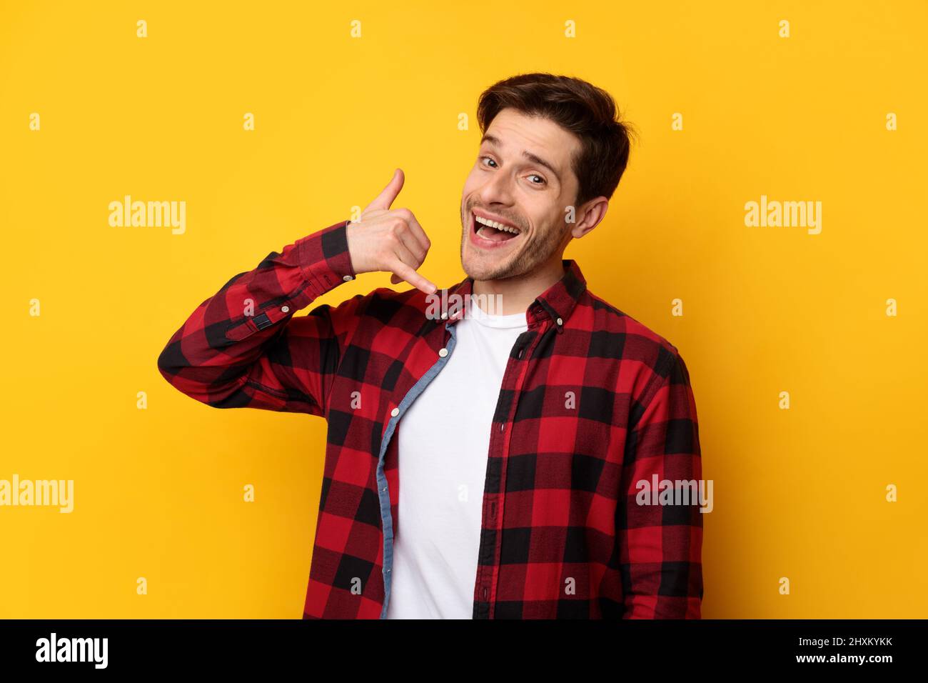 Portrait of smiling man making call me gesture Stock Photo