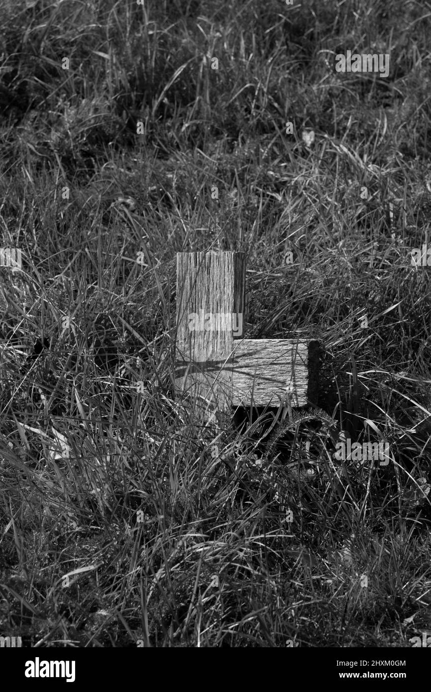 Forlorn and weathered wooden  anonymous memorial cross or grave marker in the graveyard of St Mary the Virgin church, Silchester, Hampshire. Stock Photo