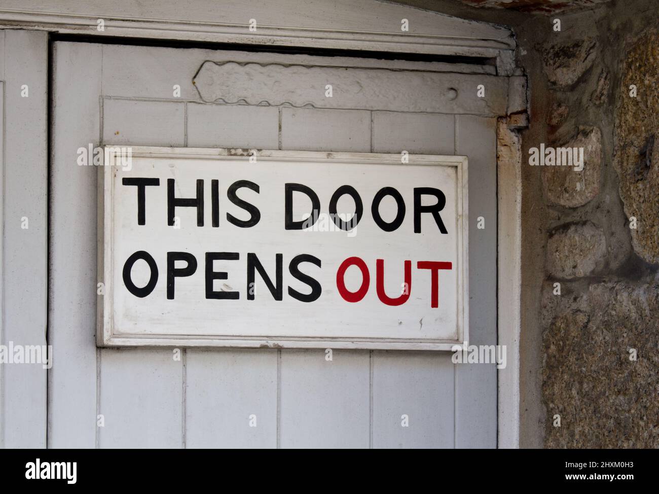 This door opens out. Warning for the unwary or confused. A building in St Ives, Cornwall. Stock Photo