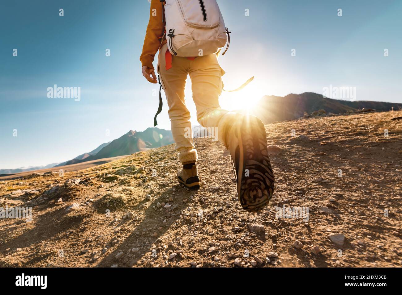 Female hiker walks in mountains. Close up photo of legs Stock Photo