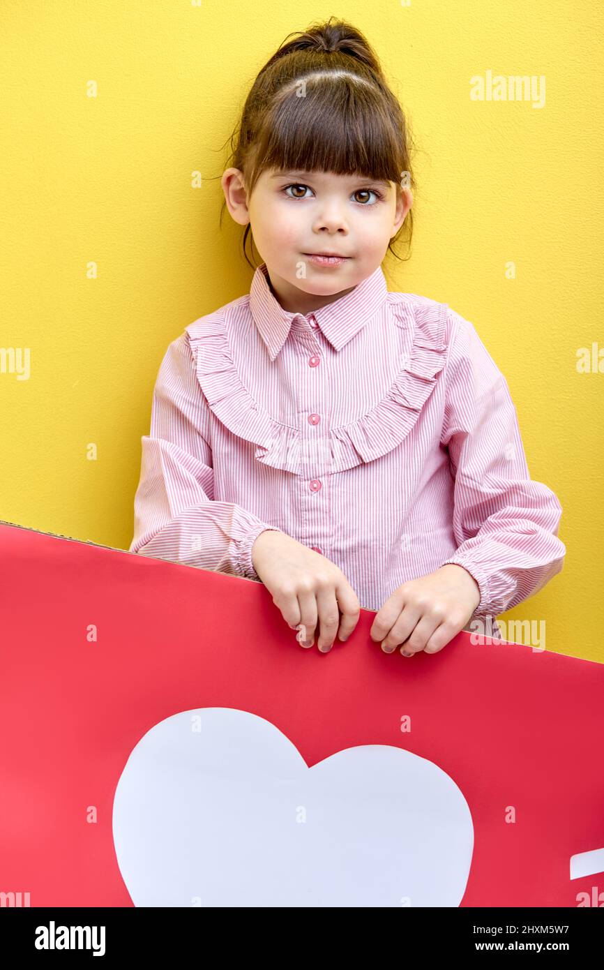 happy little girl want more likes and attention in blog, portrait of young blogger with like heart sign. internet, blogging, children, people lifestyl Stock Photo