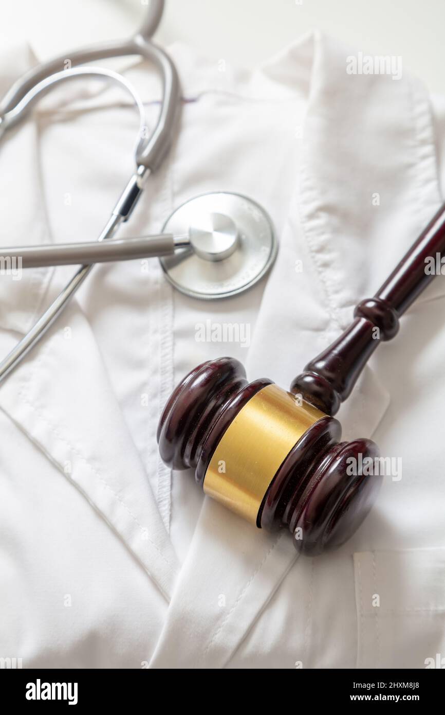 Health and Law. Medical malpractice, personal injury lawyer. Judge gavel and stethoscope on doctor coat, top view Stock Photo