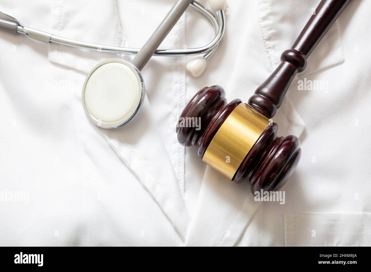 Medical malpractice, personal injury lawyer. Health and Law. Judge gavel and stethoscope on doctor coat, top view Stock Photo
