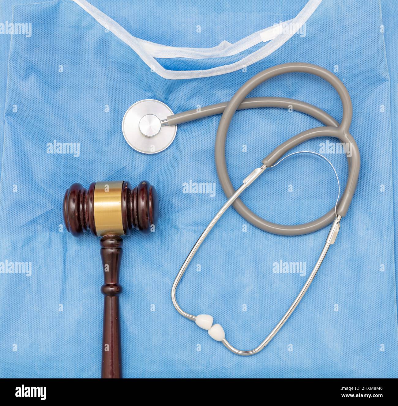 Health and Law. Medical malpractice, personal injury lawyer. Judge gavel and doctor stethoscope on surgeon coat, top view Stock Photo