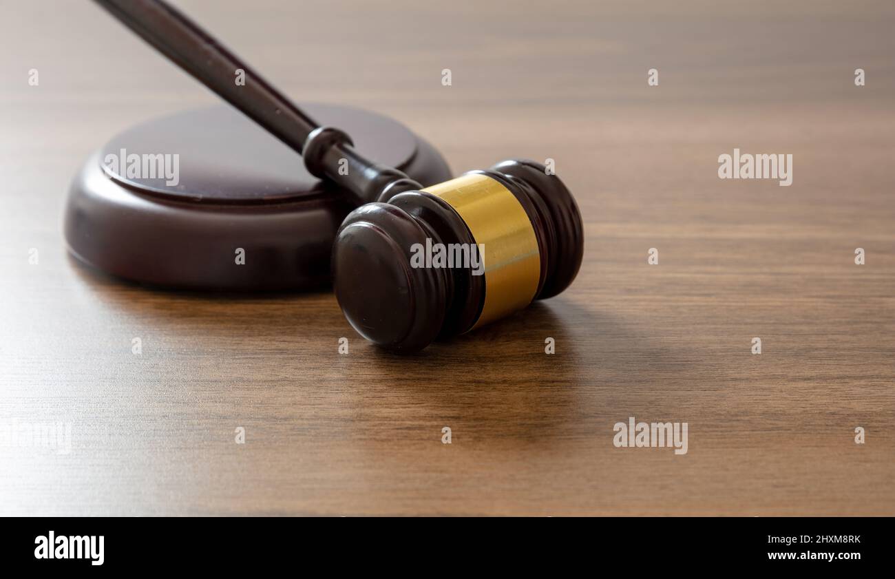 Judge gavel on lawyer office desk. Law or auction concept. Wooden courthouse table, close up view, copy space. Stock Photo