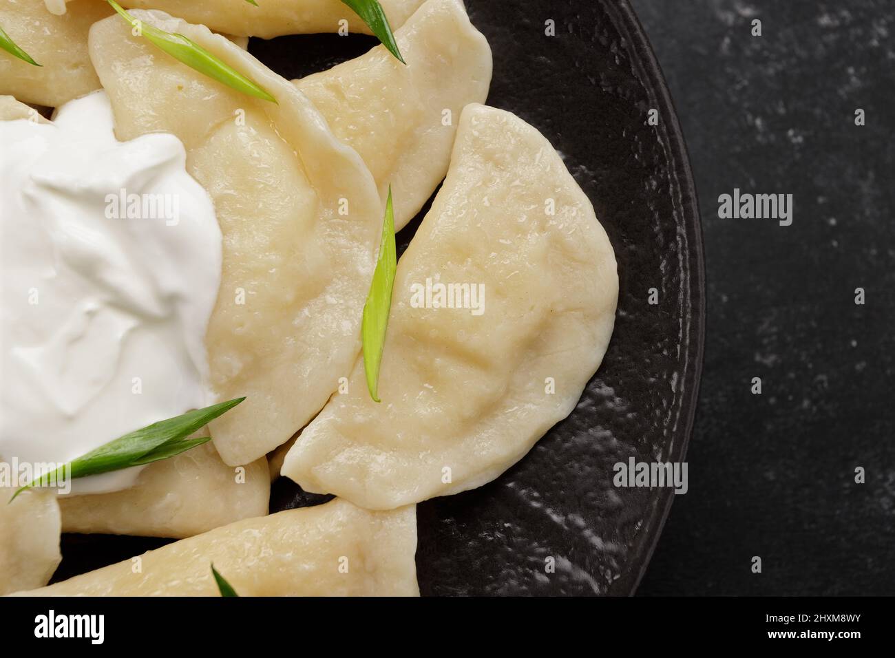 Boiled Ukrainian dumplings on a dark background Stock Photo