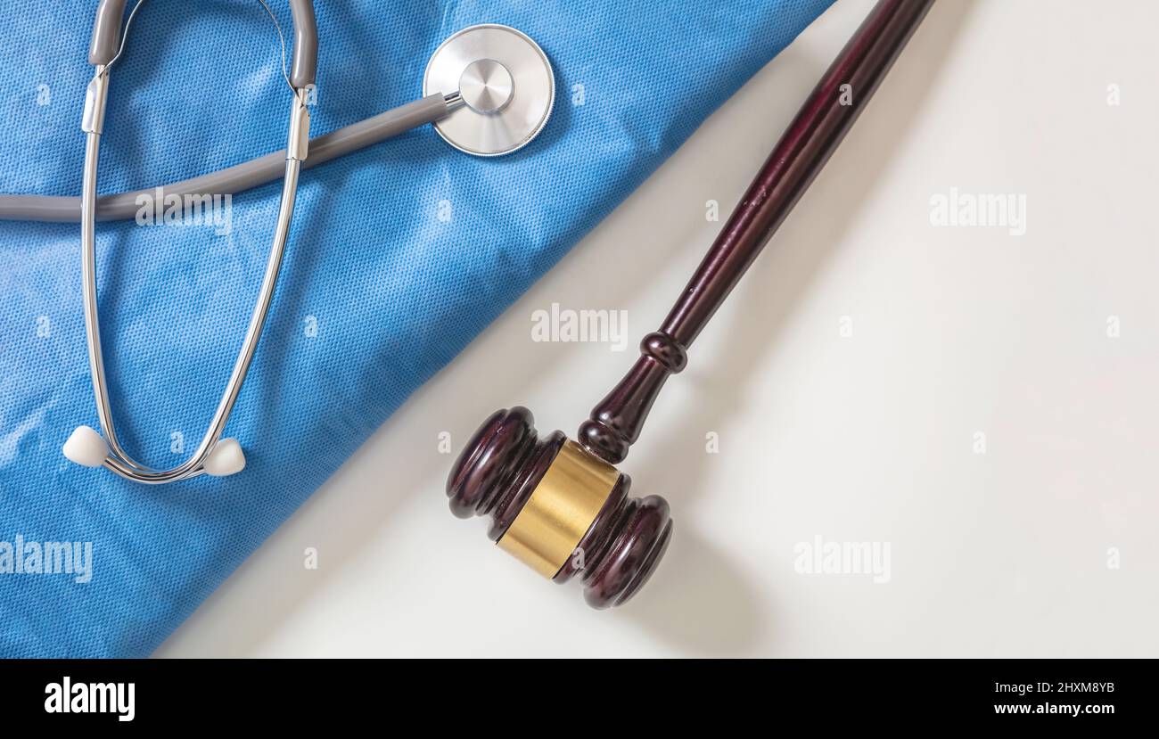 Medical malpractice, personal injury lawyer. Health and Law. Judge gavel, doctor stethoscope and surgeon coat, on white background, top view Stock Photo