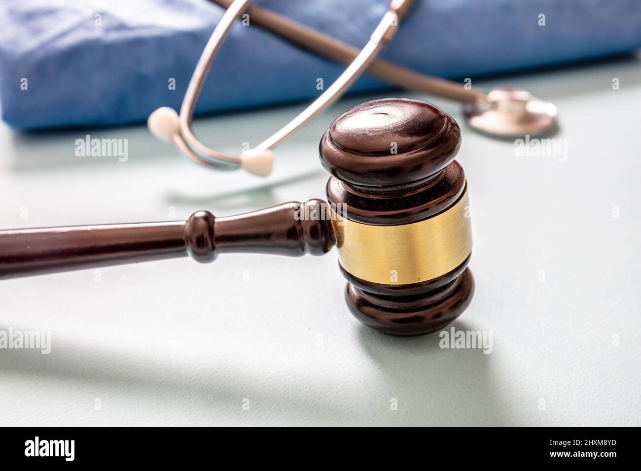 Medical malpractice, personal injury lawyer. Health and Law. Judge gavel, doctor stethoscope and surgeon coat, on white background, close up view Stock Photo