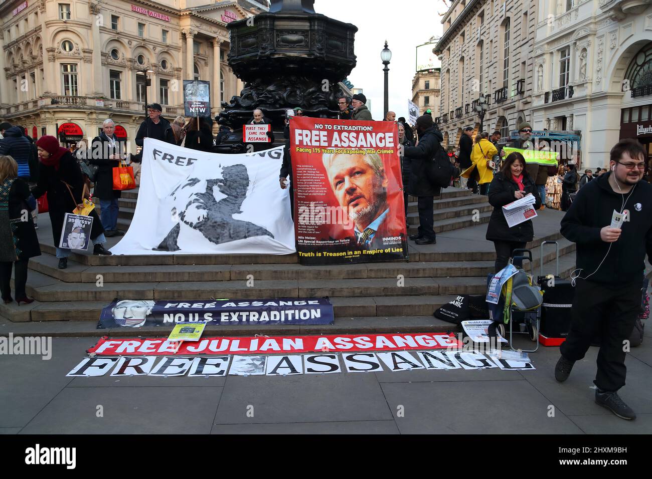 A small group of demonstrators holding placards campaign to free Julian Assange from prison at Piccadilly Circus, London, UK Stock Photo