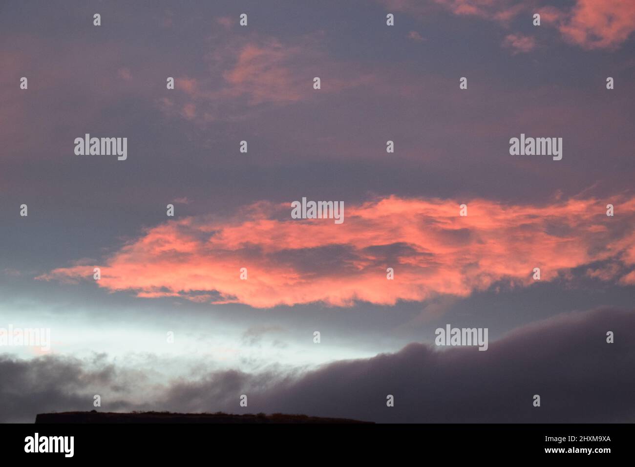 Shapes and patterns in the clouds set ablaze by the setting sun. Stock Photo